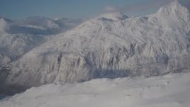 4K aerial stock footage flying over a snowy summit toward Chugach Mountains, Passage Canal, Alaska Aerial Stock Footage | AK0001_1910