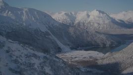 4K aerial stock footage approaching a river valley next to Carmen Lake, Alaska in snow Aerial Stock Footage | AK0001_1920