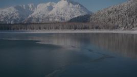 4K aerial stock footage video flying over surface of Carmen Lake approaching snow covered shore, Alaska Aerial Stock Footage | AK0001_1924