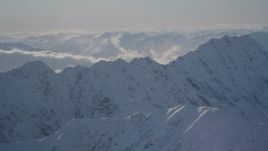 4K aerial stock footage snow covered mountain ranges and low clouds in Chugach Mountains, Alaska Aerial Stock Footage | AK0001_1975