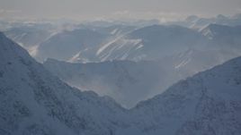 4K aerial stock footage snow covered windblown mountains and low clouds in Kenai Mountains, Alaska Aerial Stock Footage | AK0001_1976