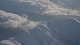 4K aerial stock footage cloudy Kenai Mountains, snow covered, windblown Chugach Mountains, Alaska Aerial Stock Footage | AK0001_1985