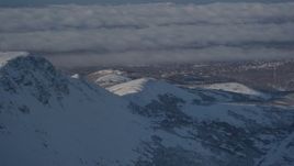 4K aerial stock footage cloud covered Anchorage, seen from snow covered Chugach Mountains, Alaska Aerial Stock Footage | AK0001_1997