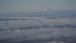 4K aerial stock footage snowy Mount Susitna near Point MacKenzie, clouds covering Anchorage, Alaska Aerial Stock Footage | AK0001_2003