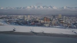 4K aerial stock footage snowy Downtown Anchorage, descend toward frozen shore of Cook Inlet, Alaska Aerial Stock Footage | AK0001_2020