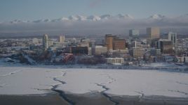4K aerial stock footage fly over frozen shore of Cook Inlet toward snowy Downtown Anchorage, Alaska Aerial Stock Footage | AK0001_2021