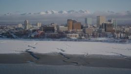 4K aerial stock footage tilt up from surface of Cook Inlet revealing snowy Downtown Anchorage, Alaska Aerial Stock Footage | AK0001_2023