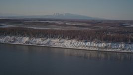 4K aerial stock footage flying over snowy, wooded shore of Point MacKenzie, Alaska Aerial Stock Footage | AK0001_2033