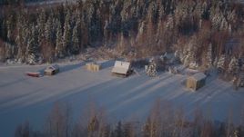 4K aerial stock footage fly by small cabins near snowy forest in Point MacKenzie, Alaska Aerial Stock Footage | AK0001_2036