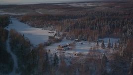 4K aerial stock footage flying away from cabins in snowy woods in Point MacKenzie, Alaska Aerial Stock Footage | AK0001_2037