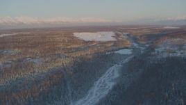 4K aerial stock footage flying over snowy forest toward Shawn Field at sunset, Wasilla, Alaska Aerial Stock Footage | AK0001_2072