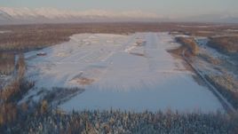 4K aerial stock footage descending toward snowy runway of Shawn Field at sunset, Wasilla, Alaska Aerial Stock Footage | AK0001_2073