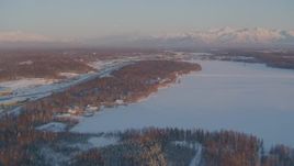 4K aerial stock footage Lucile Lake, moon over snowy Chugach Mountains at sunset, Wasilla, Alaska Aerial Stock Footage | AK0001_2076