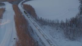 4K aerial stock footage a snow covered train running by Jacobsen Lake at sunset, Wasilla, Alaska Aerial Stock Footage | AK0001_2080