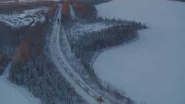 4K aerial stock footage a snow covered train running around Jacobsen Lake at twilight, Wasilla, Alaska Aerial Stock Footage | AK0001_2081