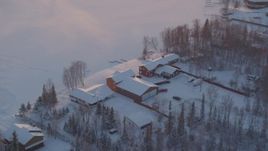 4K aerial stock footage orbiting a snow covered house on Lucile Lake at sunset, Wasilla, Alaska Aerial Stock Footage | AK0001_2084