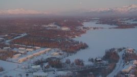 4K aerial stock footage flying over snow covered Wasilla near Wasilla Lake at sunset, Alaska Aerial Stock Footage | AK0001_2088