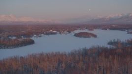 4K aerial stock footage snowy, wooded shore of Cottonwood Lake, Finger Lake, Wasilla, Alaska, twilight Aerial Stock Footage | AK0001_2091