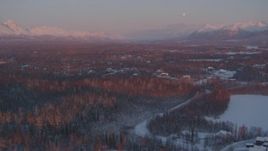 4K aerial stock footage over snow covered homes, Walby Lake, reveal mountains, Palmer, Alaska, twilight Aerial Stock Footage | AK0001_2093