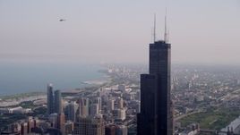4.8K aerial stock footage of an orbit of the top of the Willis Tower in Downtown Chicago, on a hazy day, Illinois Aerial Stock Footage | AX0001_044