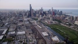 4.8K aerial stock footage tiliting from train yards by the Chicago River, revealing downtown skyline on a hazy day, Downtown Chicago, Illinois Aerial Stock Footage | AX0001_076