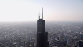 4.8K aerial stock footage orbiting the top of Willis Tower in Downtown Chicago, on a hazy day, Illinois Aerial Stock Footage | AX0001_082