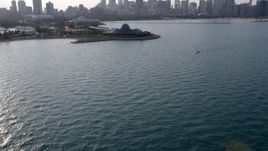 4.8K aerial stock footage tilt from the lake to reveal Adler Planetarium and Downtown Chicago skyline, Illinois Aerial Stock Footage | AX0001_099