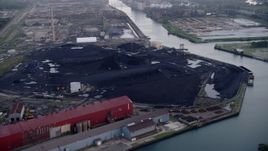 4.8K aerial  video approach petroleum coke piles by the Calumet River, East Side Chicago, Illinois Aerial Stock Footage | AX0001_169