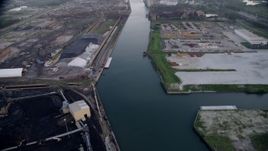 4.8K aerial  video tilt from bird's eye of petroleum coke by the Calumet River, revealing more industrial buildings, East Side Chicago, Illinois Aerial Stock Footage | AX0001_170