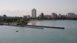 4.8K aerial stock footage flying over piers on Lake Michigan toward a beach and apartment buildings in Hyde Park, Chicago, Illinois Aerial Stock Footage | AX0002_002