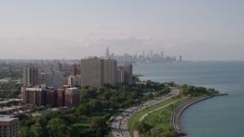 4.8K aerial stock footage tilt from Lake Michigan revealing Hyde Park apartment buildings, and the Downtown Chicago skyline, Illinois Aerial Stock Footage | AX0002_003