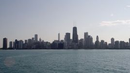 4.8K aerial stock footage fly low over Lake Michigan and tilt to reveal the skyline of Downtown Chicago, Illinois Aerial Stock Footage | AX0002_019