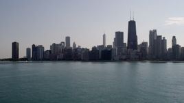 4.8K aerial stock footage of flying low over Lake Michigan, tilt up to reveal Downtown Chicago, Illinois Aerial Stock Footage | AX0002_020