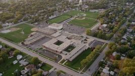 4.8K aerial stock footage tilt and flyby Thornton Fractional South High School in Lansing, at sunset, Lansing, Illinois Aerial Stock Footage | AX0003_001