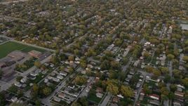 4.8K aerial stock footage of flying by a Lansing residential neighborhood revealing Coolidge Elementary School, at sunset, Lansing, Illinois Aerial Stock Footage | AX0003_002
