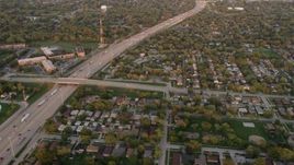 4.8K aerial stock footage of flying over residential neighborhoods and Kingery Expressway in Lansing, at sunset, Illinois Aerial Stock Footage | AX0003_003