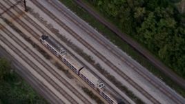 4.8K aerial stock footage of a bird's eye view of a commuter train traveling through Kenwood at twilight, Chicago, Illinois Aerial Stock Footage | AX0003_024
