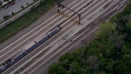 4.8K aerial stock footage of a bird's eye of a commuter train speeding through Kenwood at twilight, Chicago, Illinois Aerial Stock Footage | AX0003_025