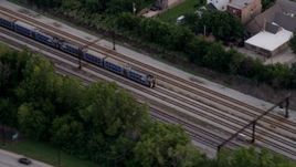 4.8K aerial stock footage of a commuter train passing through Kenwood, Chicago, Illinois, twilight Aerial Stock Footage | AX0003_026