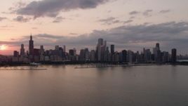4.8K aerial stock footage of the Downtown Chicago skyline at sunset seen from Lake Michigan, Illinois Aerial Stock Footage | AX0003_030