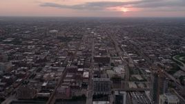 4.8K aerial stock footage follow W Fulton Street over apartment buildings in West Chicago at sunset with clouds, Illinois Aerial Stock Footage | AX0003_042