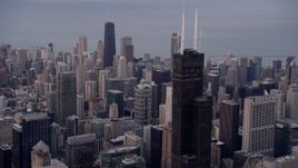 4.8K aerial stock footage of flying near Willis Tower with a view across the cityscape to John Hancock Center at sunset, Downtown Chicago, Illinois Aerial Stock Footage | AX0003_044