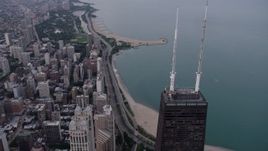 4.8K aerial stock footage of flying over top of John Hancock Center, with a view of Lake Shore Drive at sunset, Downtown Chicago, Illinois Aerial Stock Footage | AX0003_052