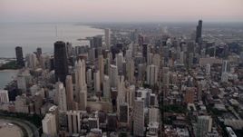 4.8K aerial stock footage of flying by the cityscape of Downtown Chicago at sunset, Illinois Aerial Stock Footage | AX0003_054