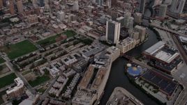 4.8K aerial stock footage tilt from apartments by the Chicago River, revealing Downtown Chicago at sunset, Illinois Aerial Stock Footage | AX0003_057