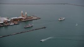4.8K aerial stock footage of ferries sailing by the end of Navy Pier, Chicago, Illinois, sunset Aerial Stock Footage | AX0003_062