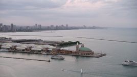4.8K aerial stock footage of orbiting two ferries by the end of the Navy Pier on a cloudy day at sunset, Illinois Aerial Stock Footage | AX0003_063