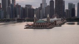 4.8K aerial stock footage of flying by Navy Pier with Ferris wheel, with Downtown Chicago behind it, on a cloudy day at sunset, Illinois Aerial Stock Footage | AX0003_066