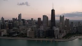 4.8K aerial stock footage of John Hancock Center and lakefront skyscrapers, seen from Lake Michigan, with clouds at twilight, Illinois Aerial Stock Footage | AX0003_070