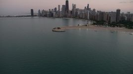 4.8K aerial stock footage tilt from Lake Michigan, revealing North Avenue Beach and Downtown Chicago skyline, at twilight, Illinois Aerial Stock Footage | AX0003_072